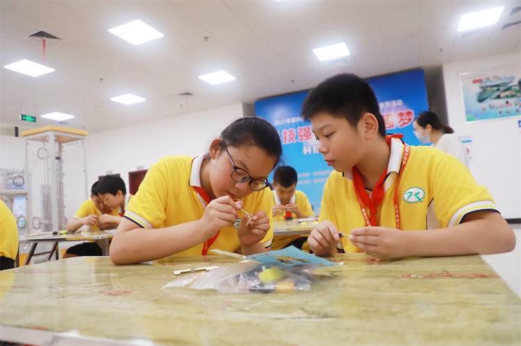 2021年7月9日鄂州市科協(xié)組織新民街小學學生在鄂州市科技館開展社會主義核心價值觀系列活動，圖為開展的科技創(chuàng)新圓夢中華科技小制作活動，孩子們正在相互配合制作蠕蟲機器人.jpg