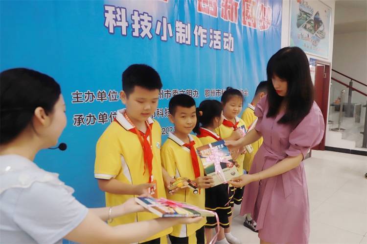 2021年7月9日鄂州市科協(xié)組織新民街小學學生在鄂州市科技館開展社會主義核心價值觀系列活動，圖為開展的科技創(chuàng)新圓夢中華科技小制作活動，科協(xié)王雨濛部長正在為優(yōu)先制作完成的學生頒發(fā)獎品.jpg