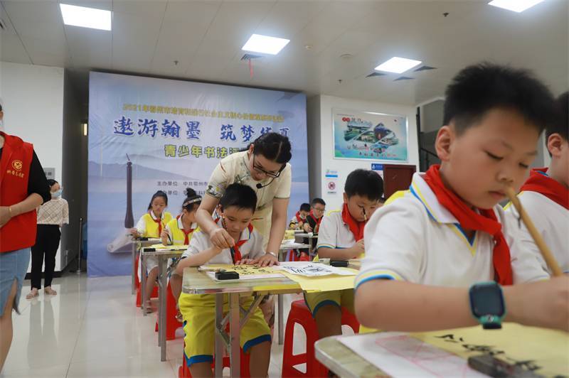 2021年7月10日，鄂州市科協(xié)組織蓮花小學(xué)學(xué)生在鄂州市科技館開展社會(huì)主義核心價(jià)值觀系列活動(dòng)，圖為開展的遨游翰墨筑夢(mèng)華夏書法活動(dòng)，老師指導(dǎo)學(xué)生.jpg